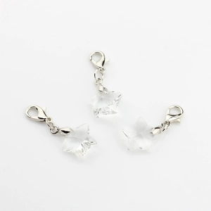 Detailed view of three crystal star pendants with silver lobster clasps on white background