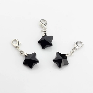 Close-up of three black faceted crystal star charms with silver lobster clasps for jewelry