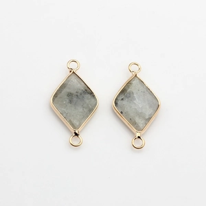 Detail of natural grey stone rhombic pendants with gold-plated edges and double jump rings