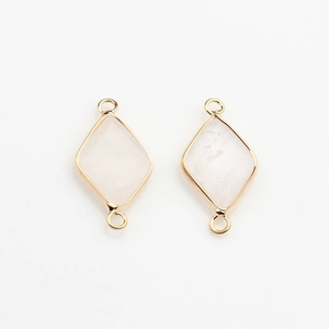 Macro shot of gold-plated rhombus light pink stone pendants with double hanging loops