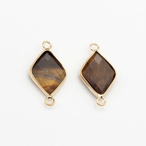 Macro detail of faceted tiger eye stone pendants with gold plated hexagonal metal frames