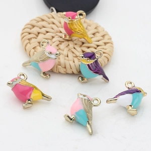 Close-up of colorful enamel bird charms in gold plating for DIY jewelry making