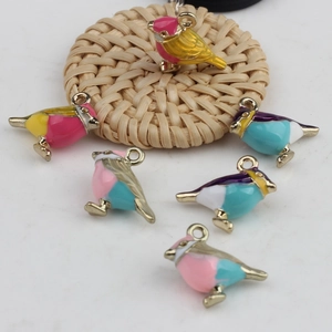 Macro detail of bird-shaped enamel alloy pendants for DIY jewelry making in multiple colors