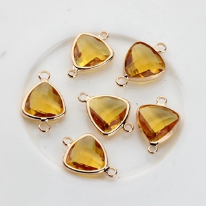 Detailed view of yellow triangular faceted crystal connectors with double gold-plated loops