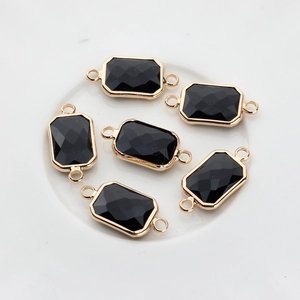 Detailed view of six black crystal rectangular pendants with gold-plated double loops