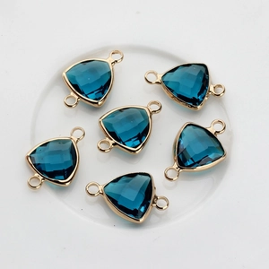 Macro detail of dark blue triangle crystal pendants with gold edges and double bail loops