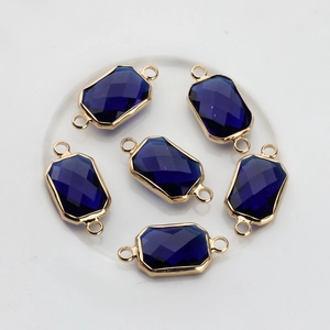 Macro shot of six navy blue rectangular faceted crystal connectors with gold trim