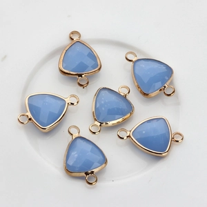 Close-up of light blue triangular crystal pendants with gold-plated copper edges and dual rings
