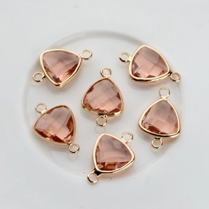 Macro shot of triangle crystal pendants with rose gold plated borders for DIY jewelry