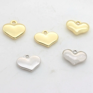 Vista detallada de colgantes de corazón en oro y plata para la creación de joyas DIY
