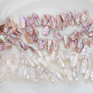Dettaglio di perle barocche d'acqua dolce iridescenti rosa e bianche con lucentezza