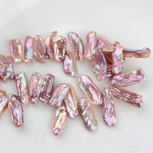 Primo piano di perle barocche d'acqua dolce rosa metallizzato con riflessi cangianti e irregolari