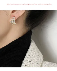 Detalle de clip de oreja árbol de Navidad con perlas y strass en la modelo