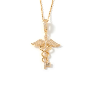 Macro shot of gold caduceus key pendant necklace with shimmering white zircon stones