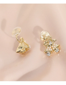 Detalle de pendientes de clip de campana de Navidad con perlas y cristales en seda