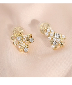 Detalle de pendientes asimétricos con árbol de Navidad y campanas sobre seda satinada