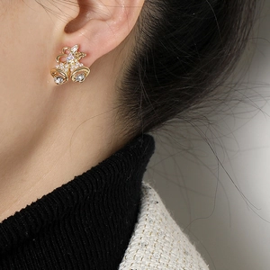 Elegantes pendientes de clip de campana navideña con lazo dorado, perlas y cristales