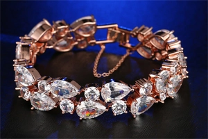 Close-up of rose gold bracelet featuring pear-cut cubic zirconia and safety chain