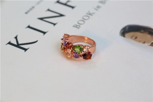 Gros plan détaillé d'une bague en or rose avec zircons colorés sur un fond de livre