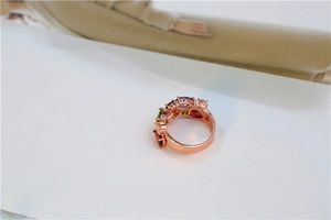 Détail d'une bague en or rose sertie de pierres multicolores de formes variées