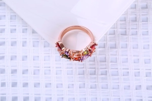 Détail d'une bague en or rose avec sept cristaux colorés taillés en poire en éventail