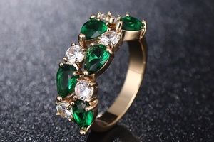 Bague en or rose avec pierres vertes taille poire et zircons blancs en gros plan