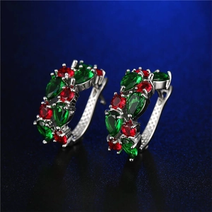 Dettaglio di orecchini a cerchio in argento con zirconi verde smeraldo e rosso rubino