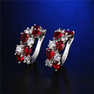 Dettaglio di orecchini in argento con zircone rosso a cuore e accenti di diamanti