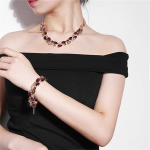 Detail view of colorful teardrop gemstone necklace and bracelet set on model