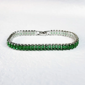 Detailed shot of silver bracelet featuring rectangular step-cut green emerald zircons