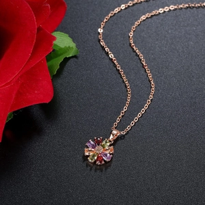 Makroaufnahme einer roségoldenen Halskette mit buntem Zirkonia-Blumenanhänger und feiner Kette