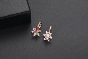 Détail de boucles d'oreilles fleurs double couche or rose avec zircons colorés