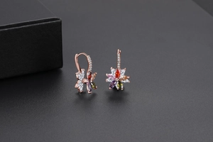 Gros plan détaillé de boucles d'oreilles fleurs en or rose avec zircons multicolores