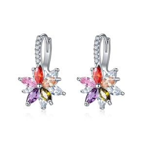 Détail macro de boucles d'oreilles fleurs double couche avec zircons colorés et métal argenté