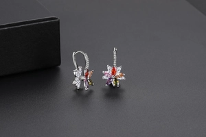 Gros plan sur les boucles d'oreilles fleur arc-en-ciel en argent et zircons colorés