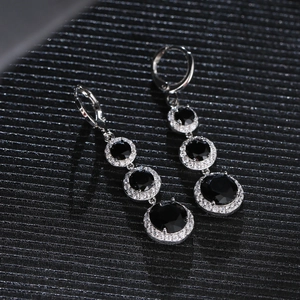 Detail showing four-tier circular black gemstones with zircon accents on silver leverback earrings