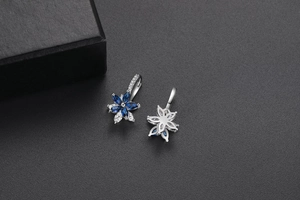 Détail de boucles d'oreilles fleurs double couche en argent avec zircons bleus et blancs