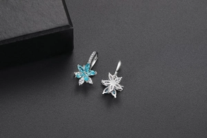 Détail macro de boucles d'oreilles fleurs bleu ciel avec sertissage en métal et zircon