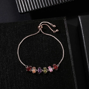 Primo piano di un bracciale regolabile in oro rosa con cristalli rettangolari colorati