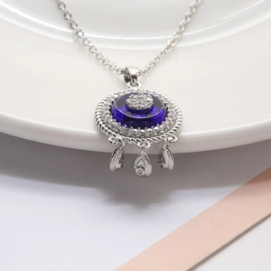 Detailed shot of Evil Eye pendant necklace with blue glass and teardrop charms