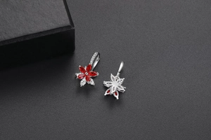 Détail de boucles d'oreilles fleur avec zircons rouges et blancs et monture argent