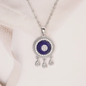 Detail of evil eye necklace with blue gemstone and three teardrop zircon pendants