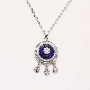 Detailed silver pendant with blue evil eye stone and micro-inlaid crystals