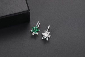 Détail des boucles d'oreilles fleurs en zircon vert double couche sur cuir noir