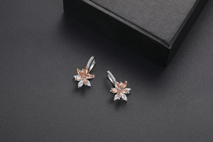 Détail de boucles d'oreilles fleur à double couche avec pierres orange et zircons