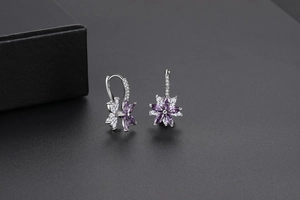 Détail de boucles d'oreilles fleurs double couche avec zircon violet et fermoir argent