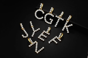 Macro detail of hip-hop gold plated alphabet pendants with pavé set zircon crystals