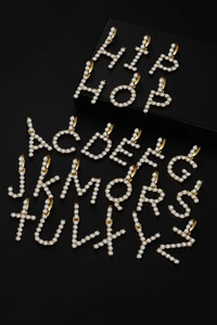 Macro shot of 26 alphabet pendants with 4mm zircon inlays in hip-hop style gold plating