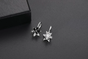 Détail de boucles d'oreilles fleurs doubles avec oxydes de zirconium noirs et blancs