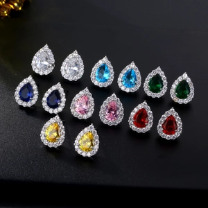 Macro shot of colorful pear-cut zircon stud earrings in seven vibrant faceted crystal shades